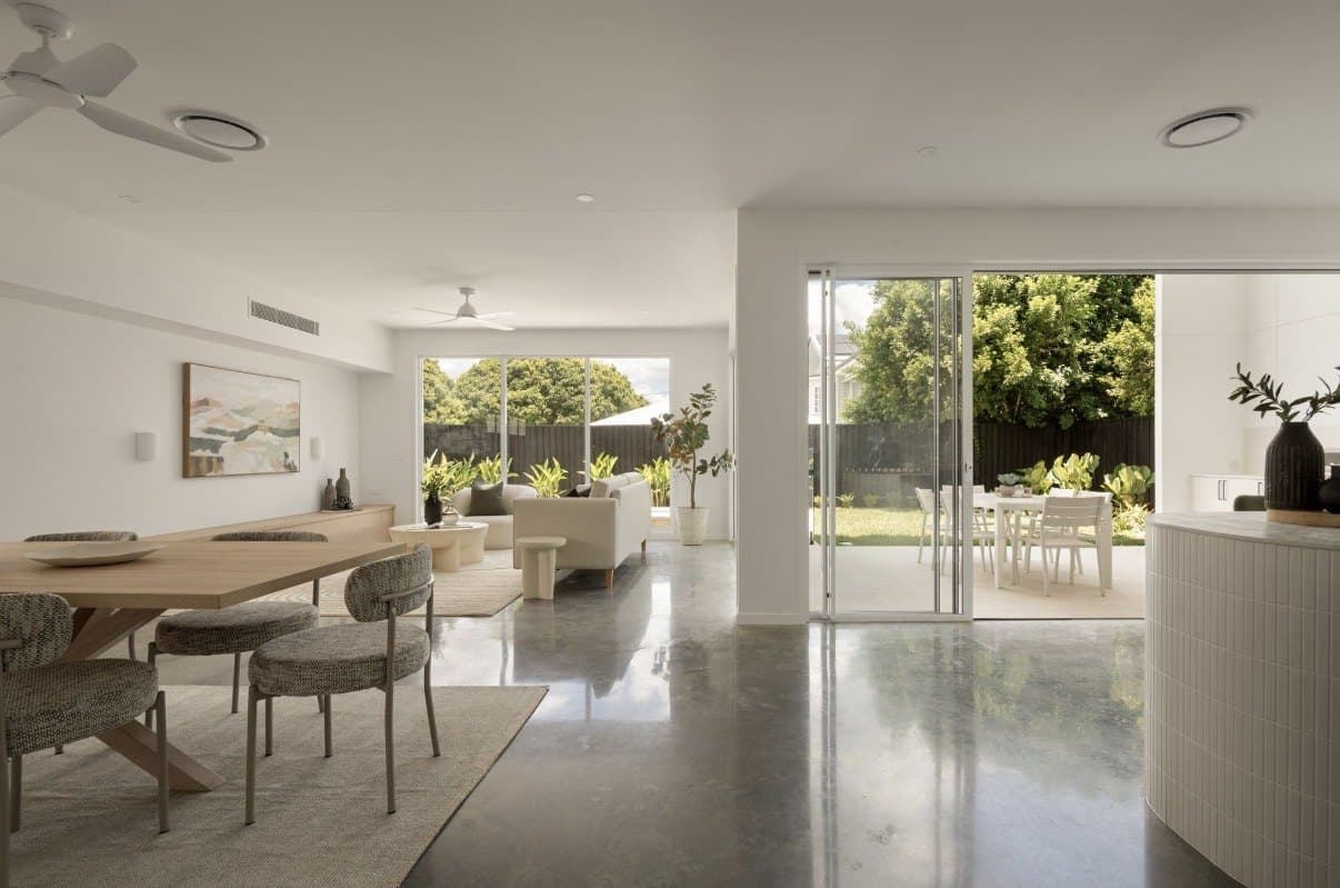 Dining area with polished concrete reflecting daylight from sliding doors