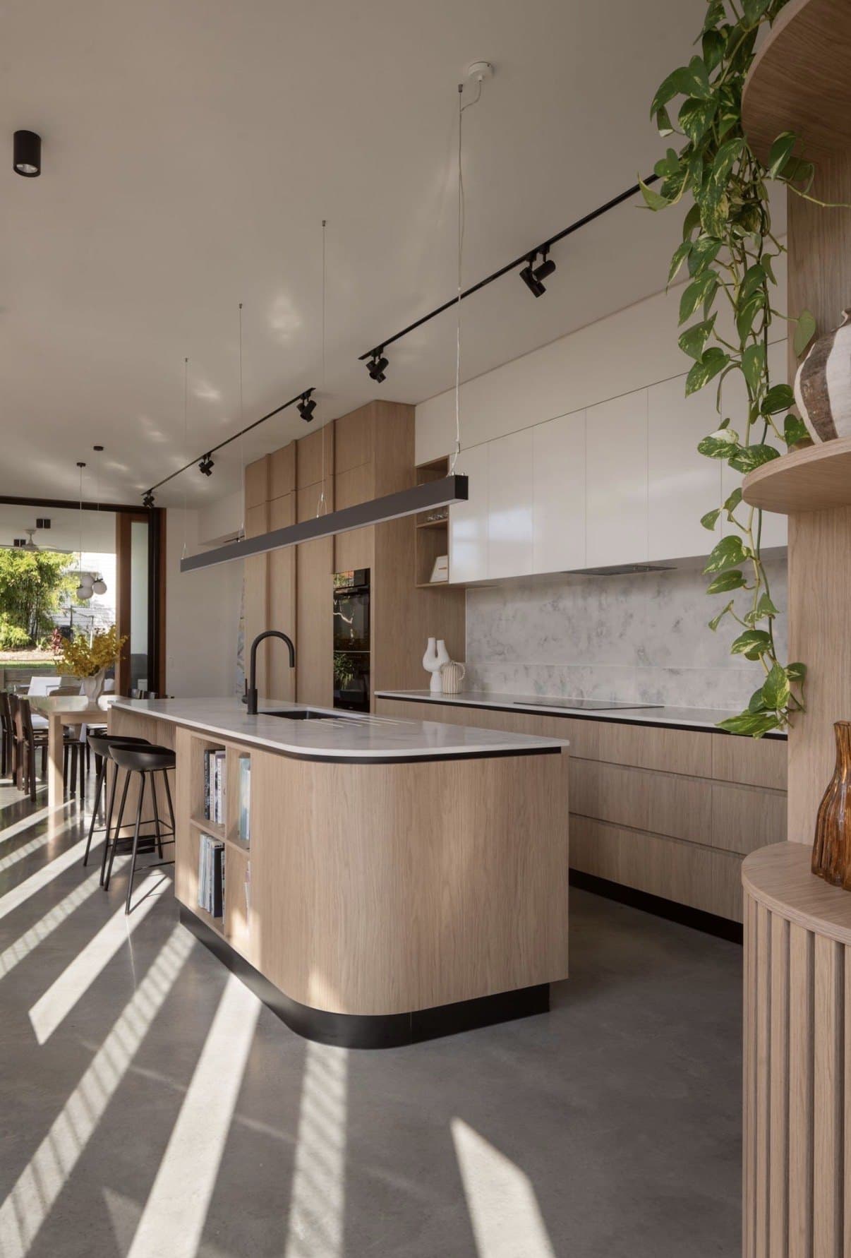 Kitchen with a satin polished concrete floor and sunlight falling through timber battens